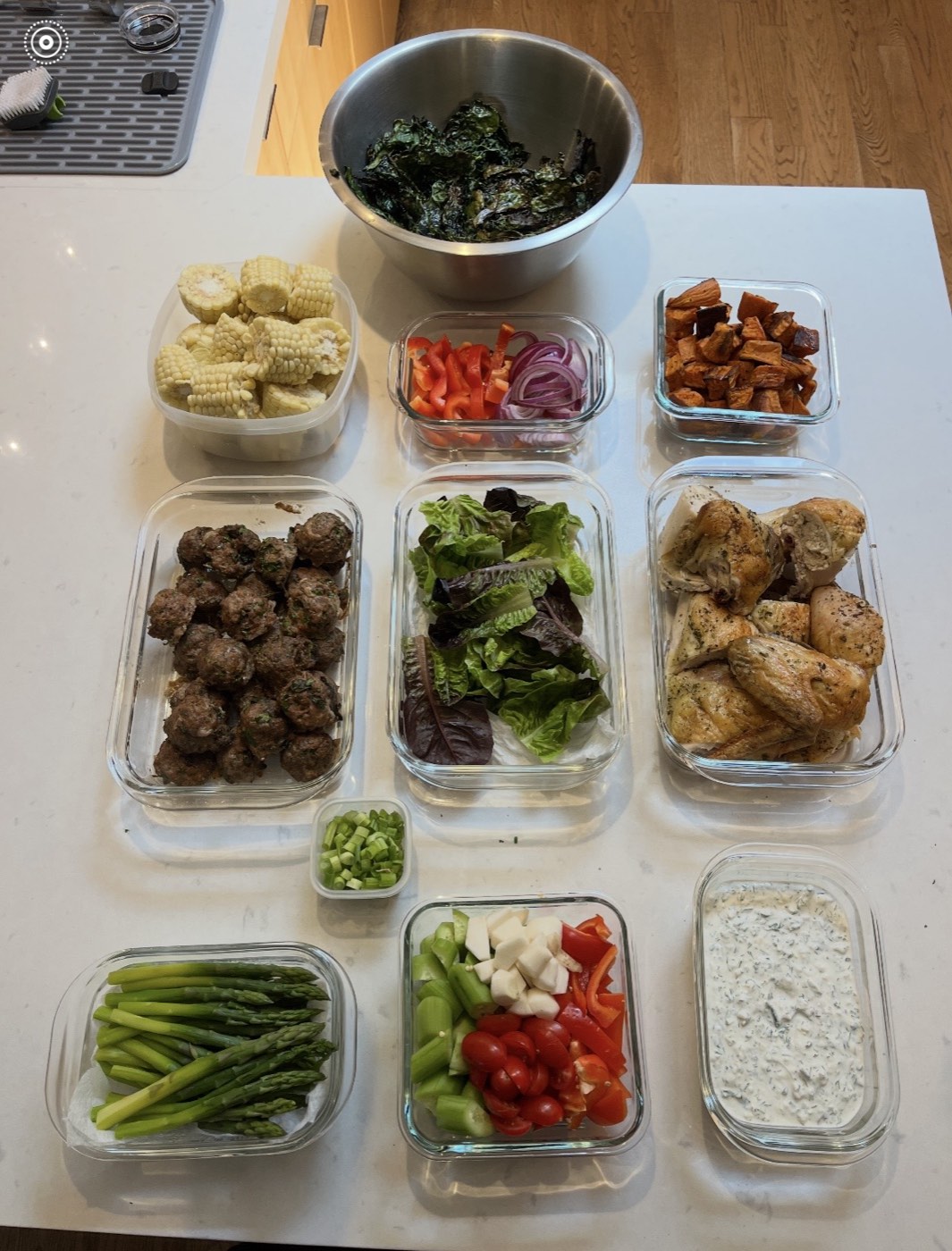 A week of meal prep containers with chicken, meatballs, and vegetables