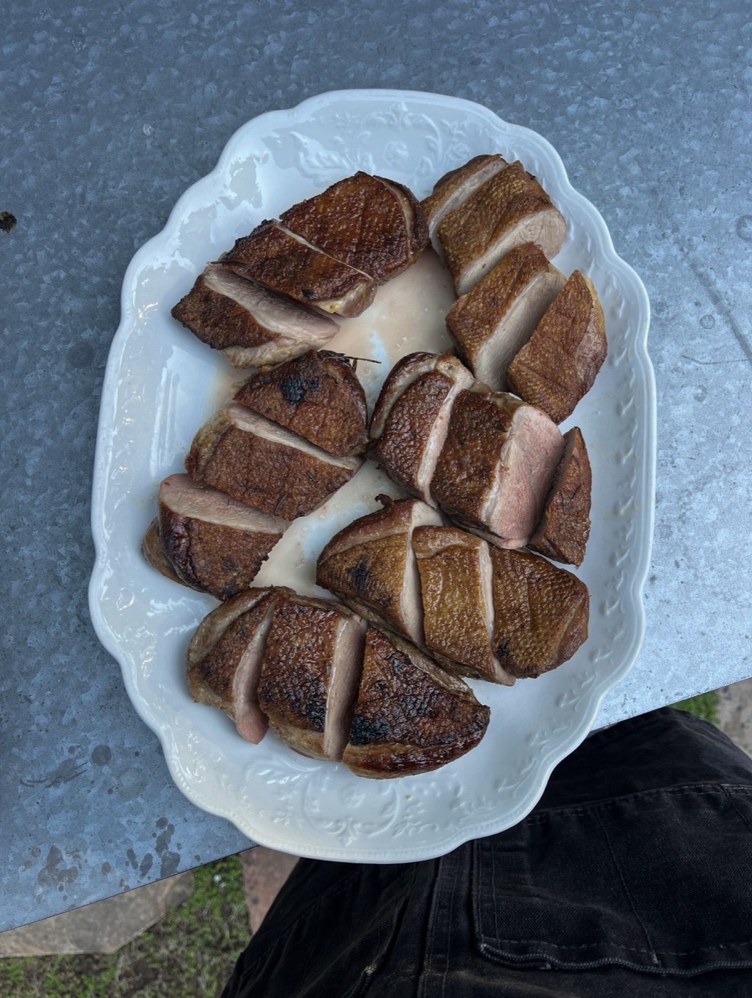 Sliced seared duck breast plated outdoors