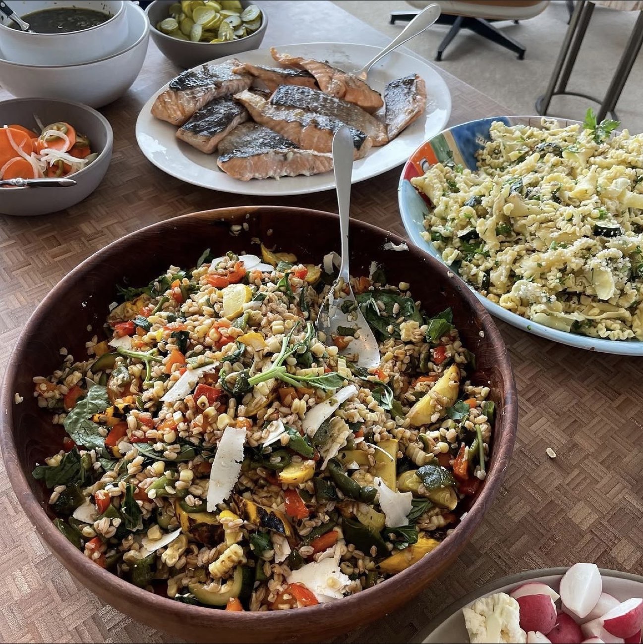Grilled salmon with grain salad, pasta salad, and pickled vegetables